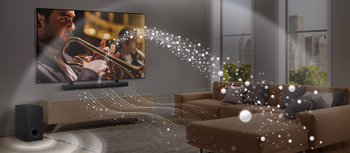 LG Soundbar, LG TV και ένα subwoofer σε ένα σύγχρονο διαμέρισμα. Το LG Soundbar εκπέμπει ηχητικά κύματα από λευκές σταγόνες που γεμίζουν το δωμάτιο και ένα subwoofer δημιουργεί ένα ηχητικό εφέ από κάτω. Συνολικά, δημιουργούν ένα εφέ θόλου σε όλο το δωμάτιο.